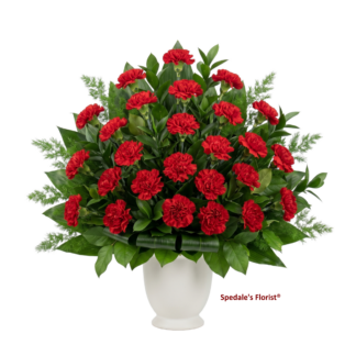 Funeral Pedestal arrangement -This classic arrangement features red carnations and assorted foliage. Designed in a white urn, this arrangement can be placed on a pedestal or on the floor